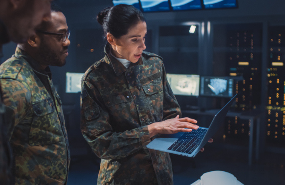 International Team of Military Personnel Have Meeting in Top Secret Facility, Female Leader Holds Laptop Computer Talks with Male Specialist. People in Uniform on Strategic Army Meeting