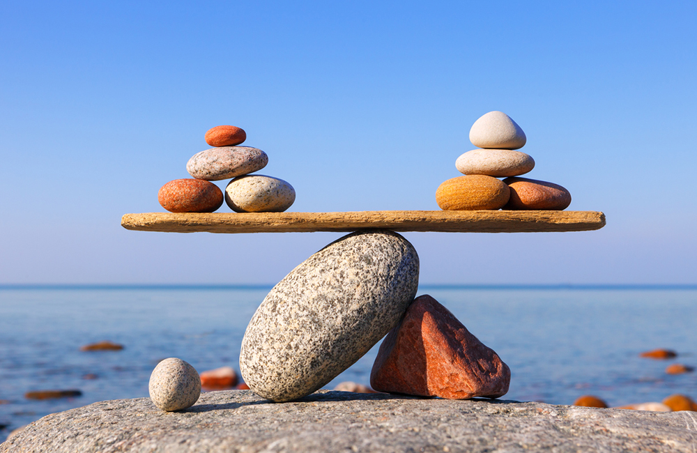 Symbolic scale of the stones on sea background. Concept of harmony and balance. work-life, emotional balance (Symbolic scale of the stones on sea background.