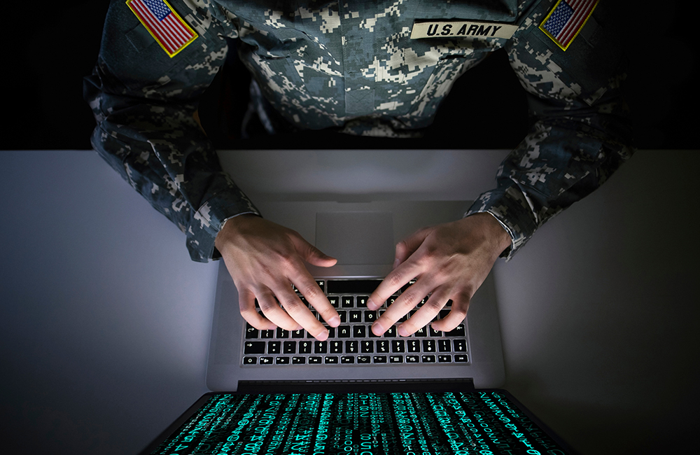 conceptual image American soldier in military uniform working on laptop with coding on screen representing the army's updated data cloud plans