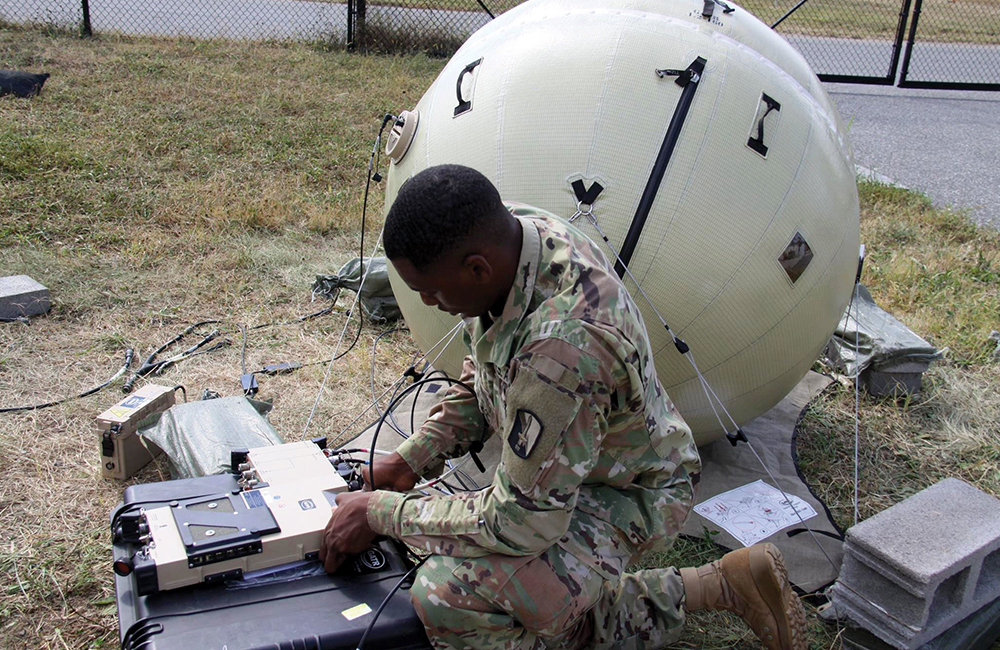 image of Combat Cameraman Spc. Christopher Bellafant tests a data transmission system as part of tactical digital media training at Aberdeen Proving Ground, Maryland.