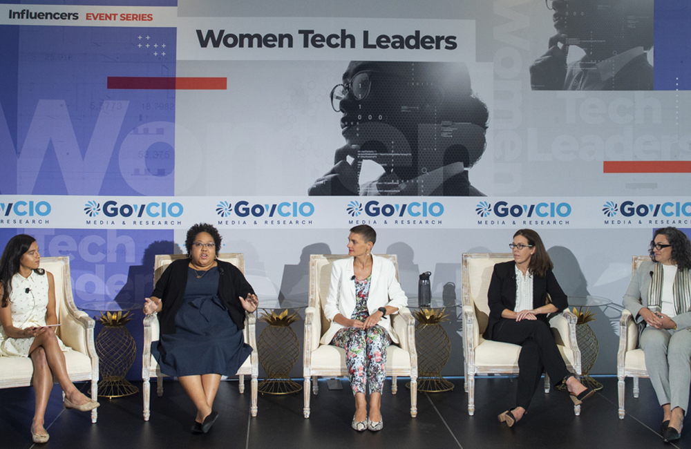 image of Army DEVCOM's Charneta Samms, Defense Department's Katie Savage, Veterans Affairs' Jennifer Moser, and RTI International's Rebecca Boyles on a panel at the July 14, 2022 Women Tech Leaders event.