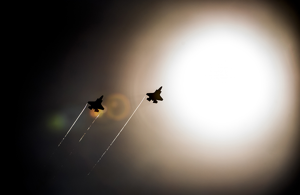 image of A pair of F-35 Lightning IIs pass under the sun while doing maneuvers to the Eglin Air Force Base runway.