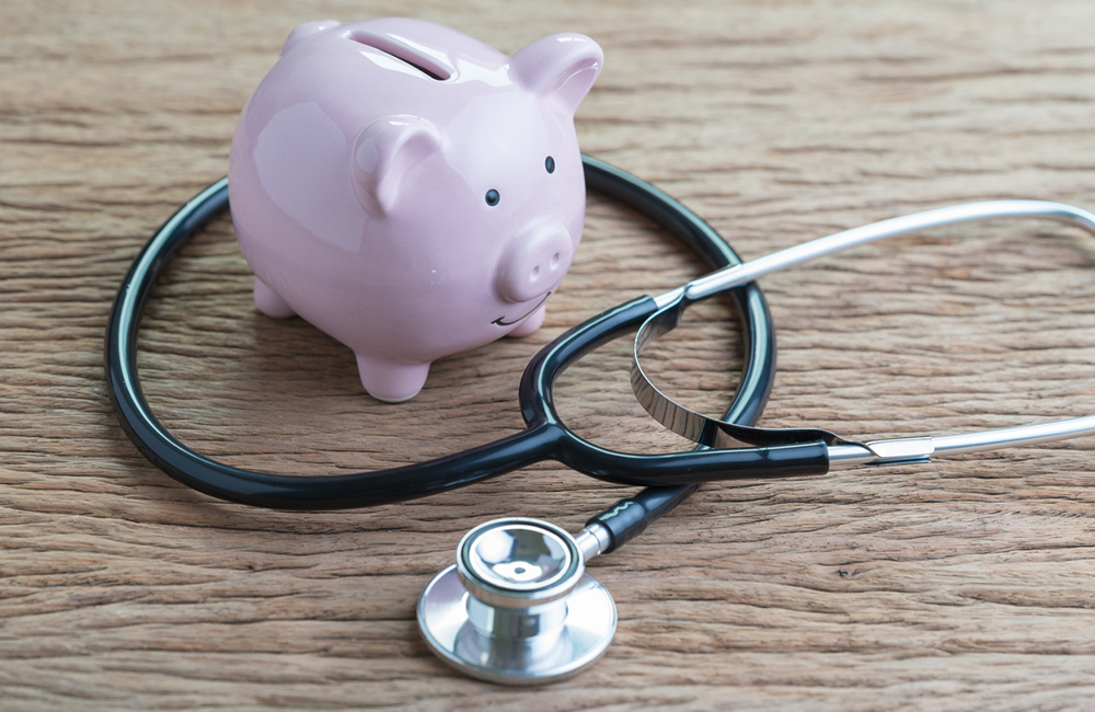 A piggy bank sits next to stethoscope