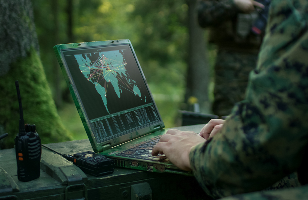 Military Operation in Action, Soldiers Using Military Grade Laptop Targeting Enemy with Satellite. In the Background Camouflaged Tent on the Forest.