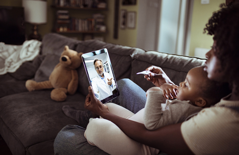 Close up of a mother and daughter consulting with their doctor over a video call on their digital tablet