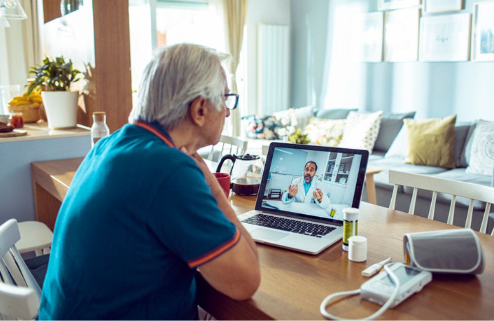 A man having a telehealth video call in his home with a doctor