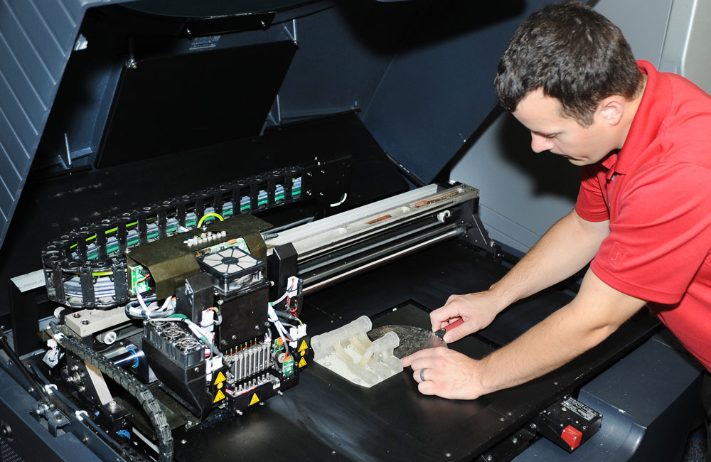 n engineer removes a 3D printed hydraulic manifold from the 3D printer July 24, 2014, at Joint Base McGuire-Dix-Lakehurst, N.J.