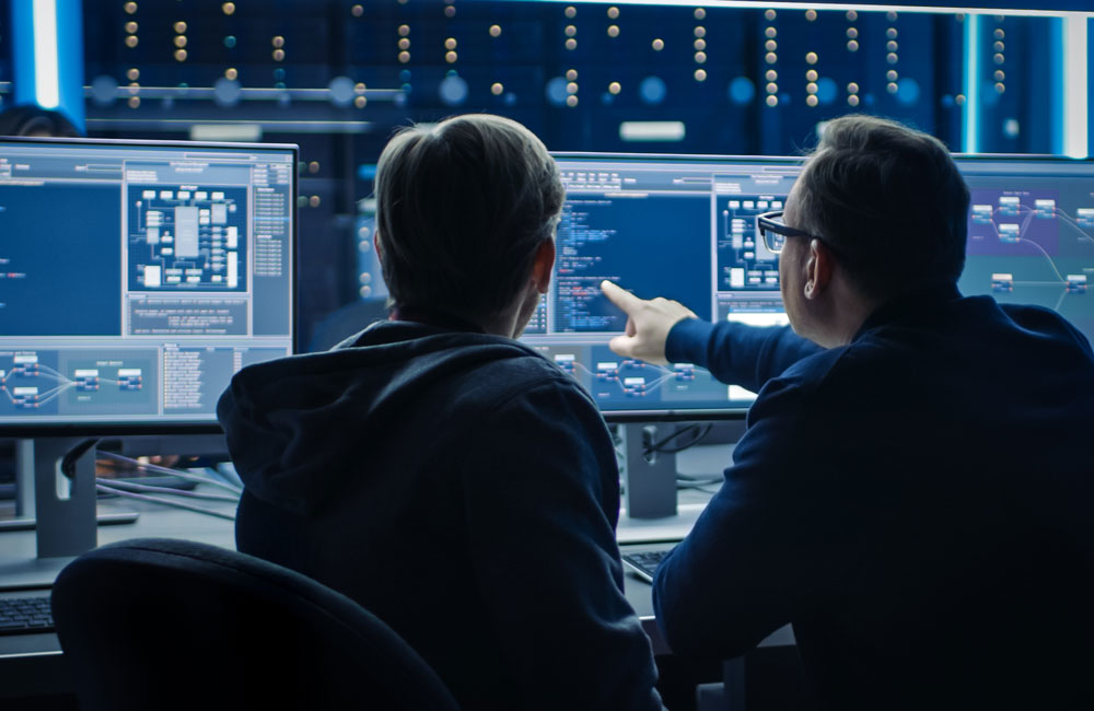 Two people point to a computer screen