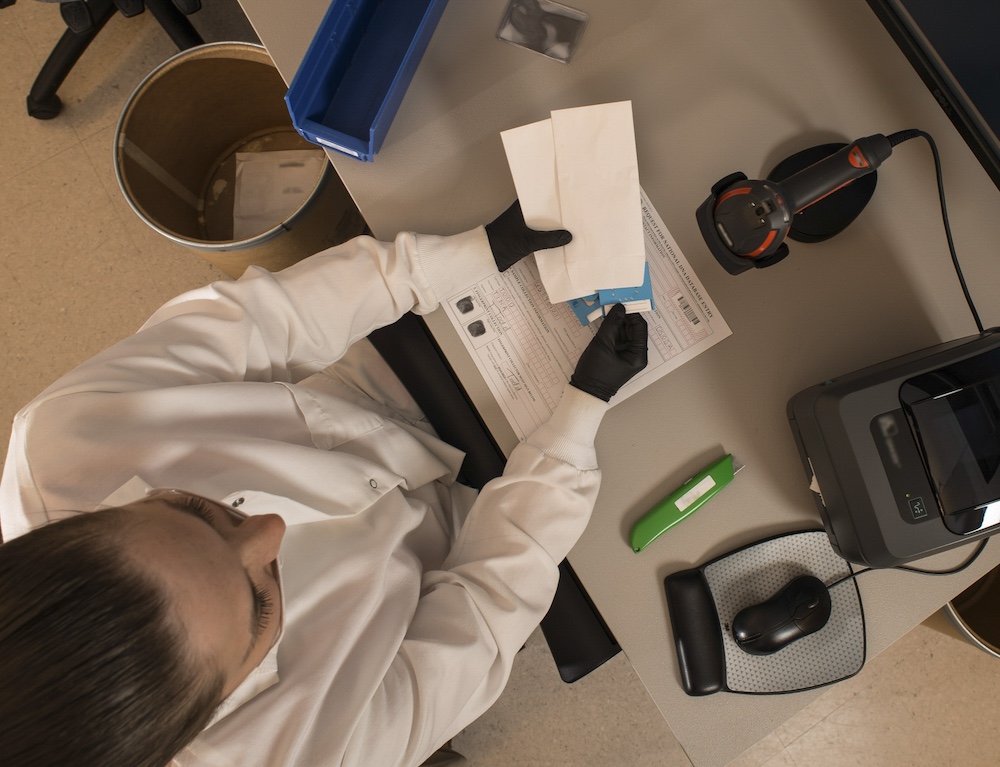 lab technician works to enter evidence into a database