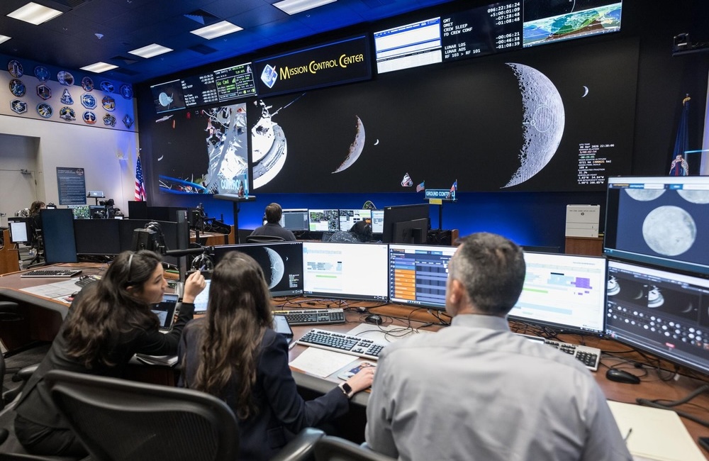 Angela Garcia, Dr. Kelsey Young and Dr. Trevor Graff, the first science officers of the Artemis program, in the White Flight Control Room in the Christopher C. Kraft Jr. Mission Control Center at NASA’s Johnson Space Center.
